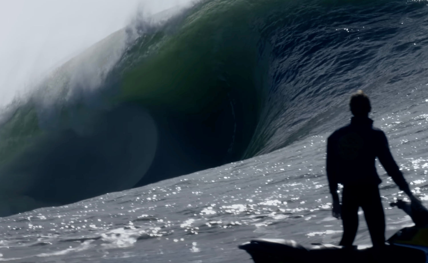 Person standing on a jet ski in front of a large wave mavricks ca winter swell
